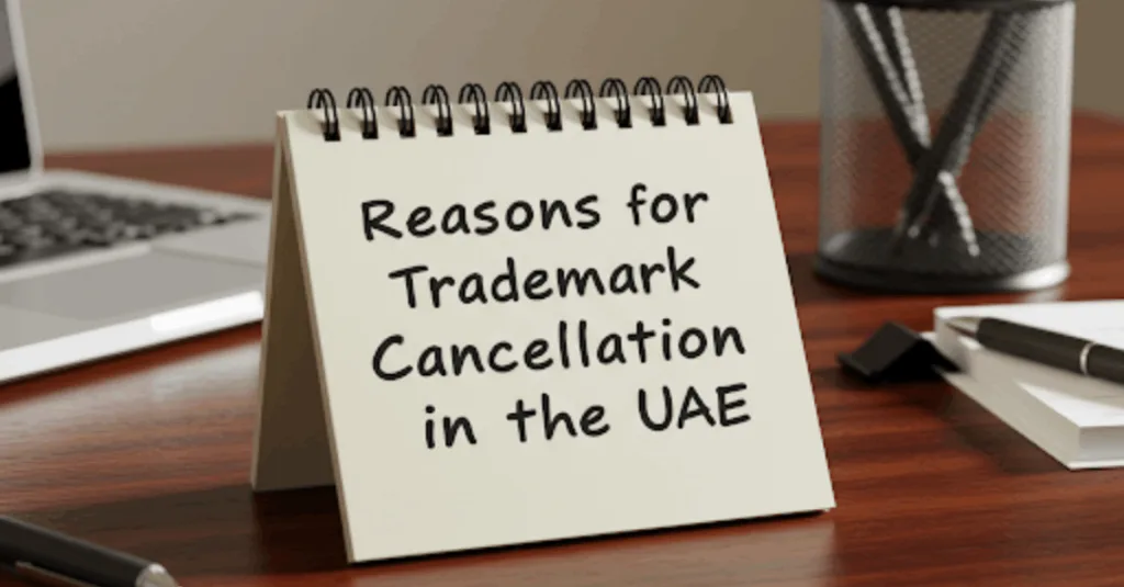 A close-up of a handwritten note on a cluttered office desk. The note reads "Reasons for Trademark Cancellation in the UAE."